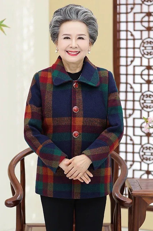 Older woman in green navy and red plaid wool jacket with black trousers