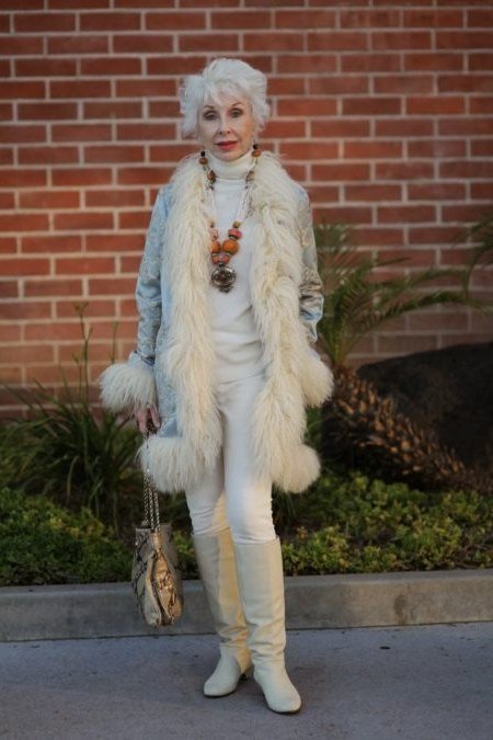 Woman in cream faux fur coat with cream knit set and cream ankle boots
