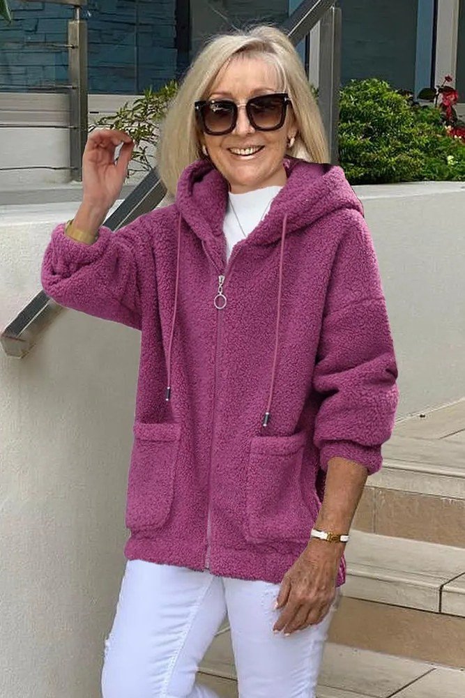 Woman wearing magenta fuzzy hoodie with white trousers