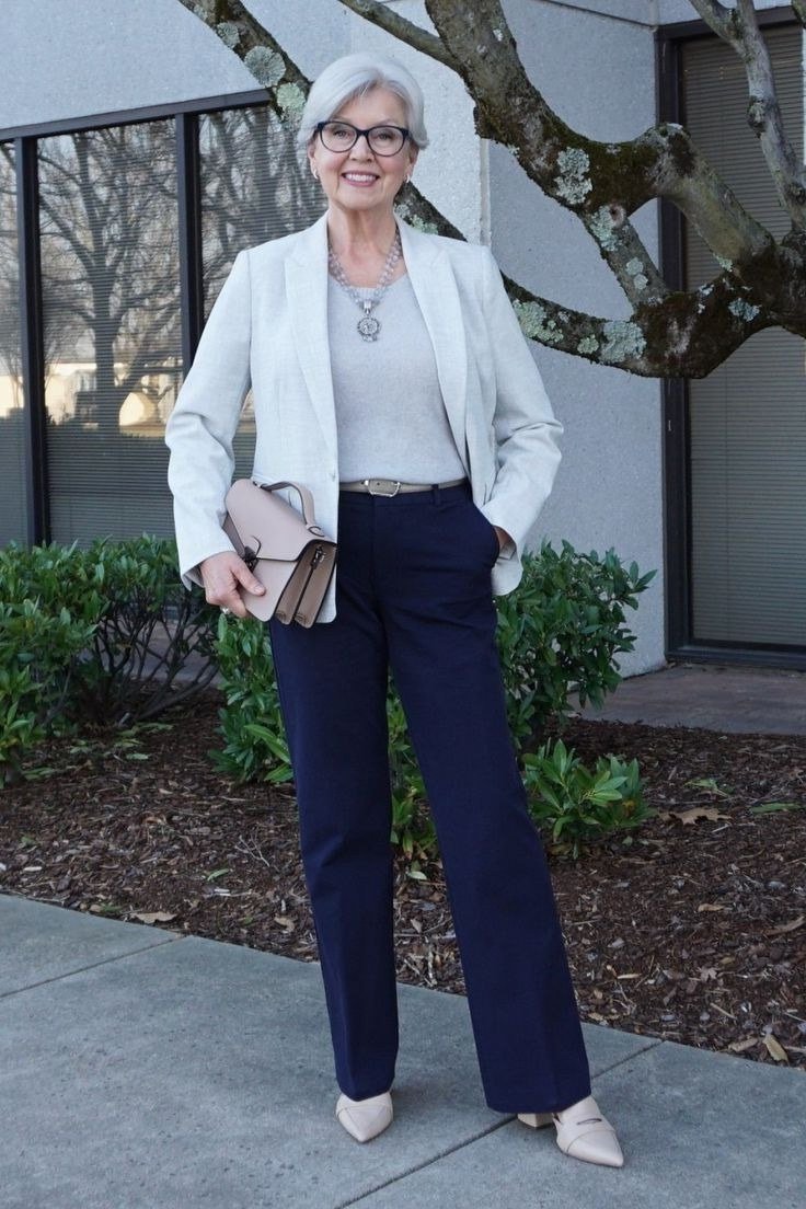 Business casual outfit for women over 50: white blazer with navy trousers and white loafers