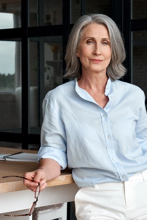 Relaxed business casual outfit for women over 50: pale blue shirt and white trousers