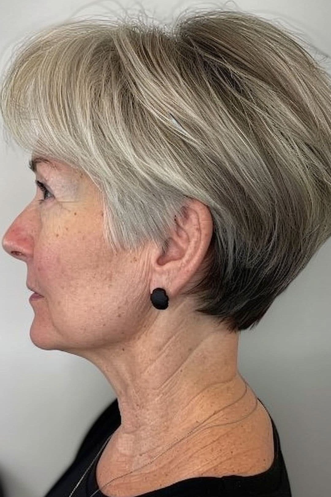 Gray stacked wedge on a woman over 60, side view - wedge bob hairstyle