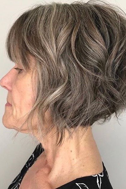 Tousled gray wedge on a woman over 60, side view - wedge bob hairstyle