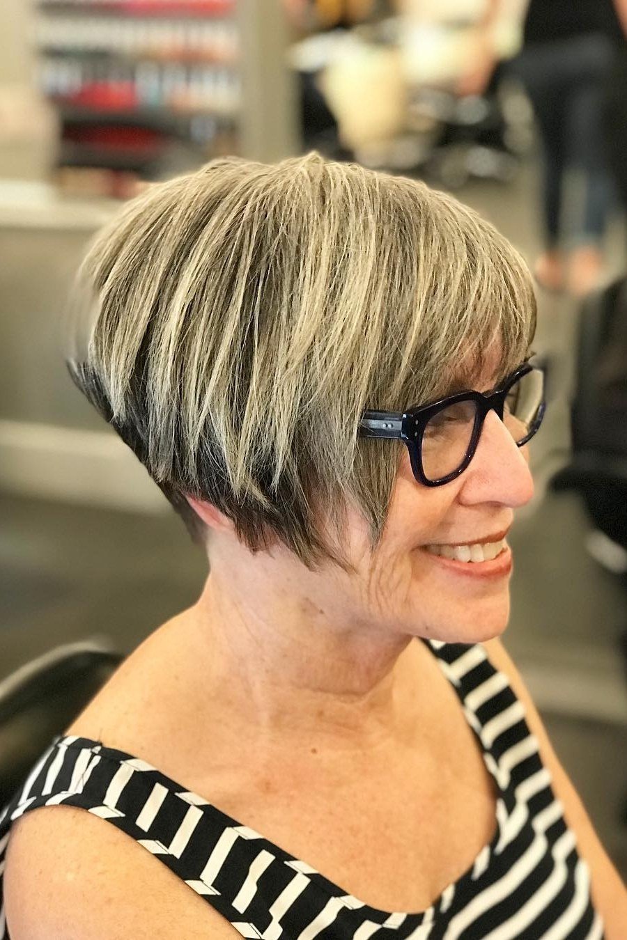 Blonde wedge with glasses on a woman over 60, three-quarter salon view - wedge bob hairstyle