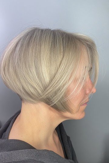 Blonde rounded wedge on a woman over 60, side view - wedge bob hairstyle