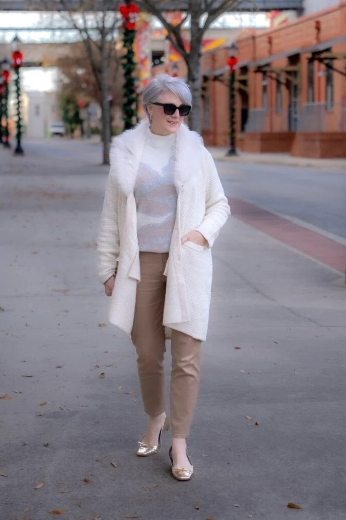 Winter outfit for women over 60: white coat, beige pants, city street
