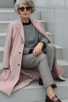 Winter outfit for women over 60: blush pink coat, houndstooth top, gray trousers