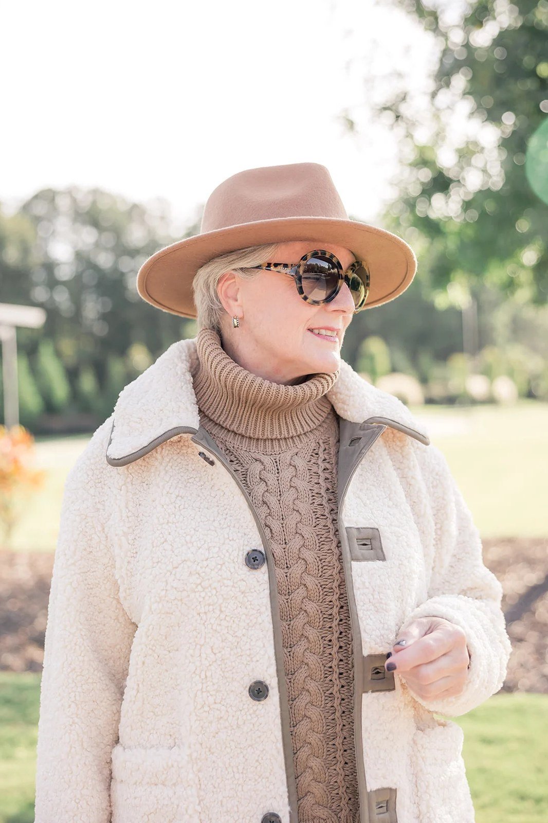Winter outfit for women over 60: cream shearling jacket, beige turtleneck, beige hat