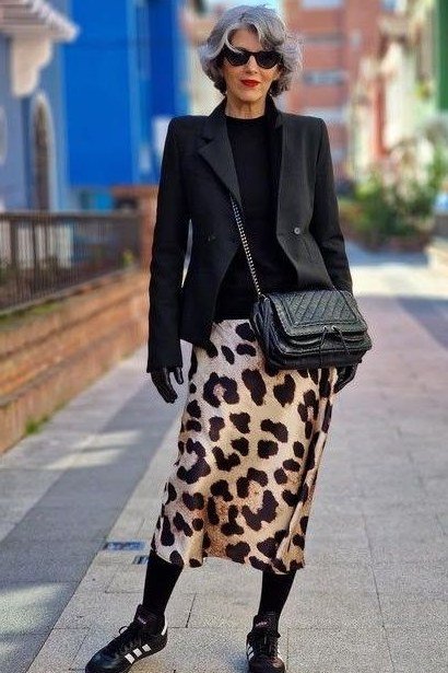 Winter outfit for women over 60: black blazer, leopard midi skirt, black tights, sneakers