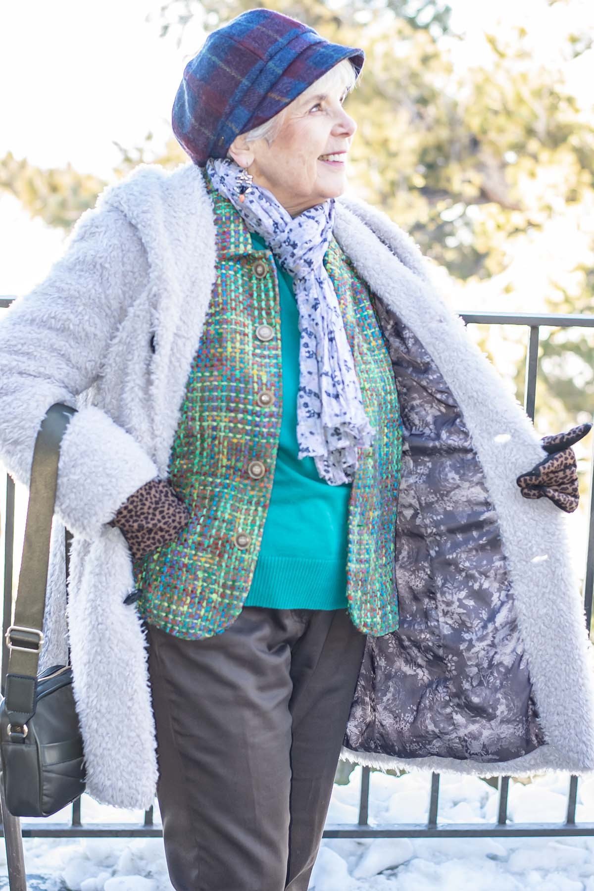 Winter outfit for women over 60: white shearling-lined coat, colorful tweed jacket, teal top