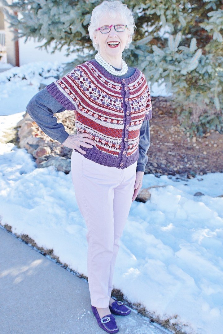 Blue and Red Fair-Isle Sweater with White Pants on a woman over 60, cozy winter casual outfit idea 13