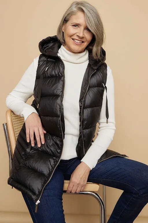 Black Puffer Vest with Cream Sweater and Jeans on a woman over 60, cozy winter casual outfit idea 45