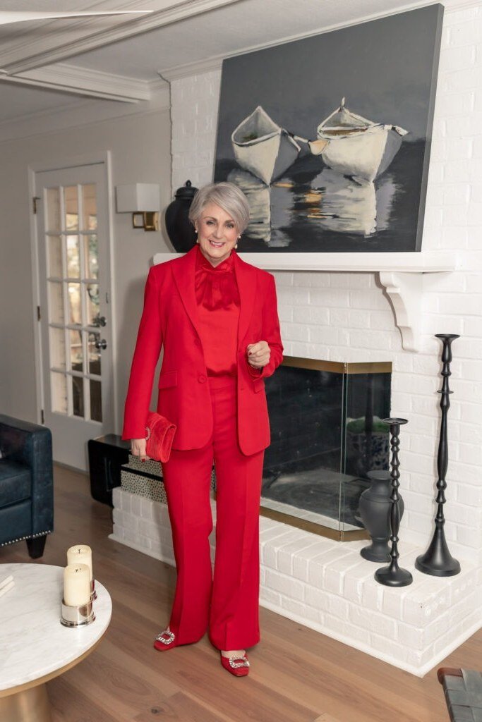 winter date night outfit for women over 60: red pantsuit with red blouse in a living room