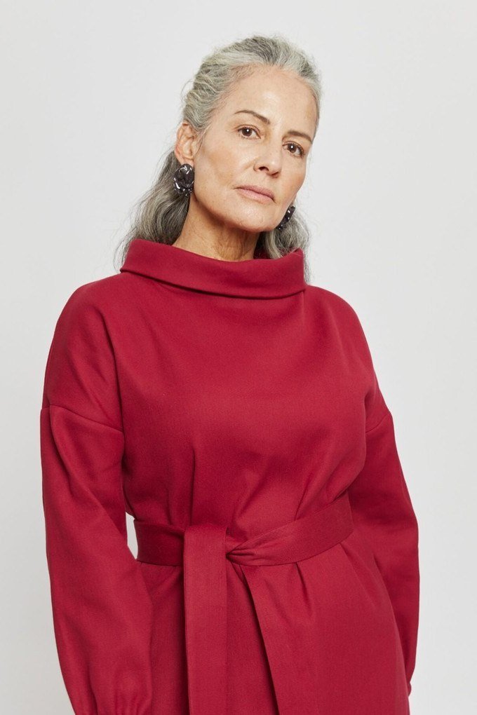 winter date night outfit for women over 60: red belted dress photographed in a studio