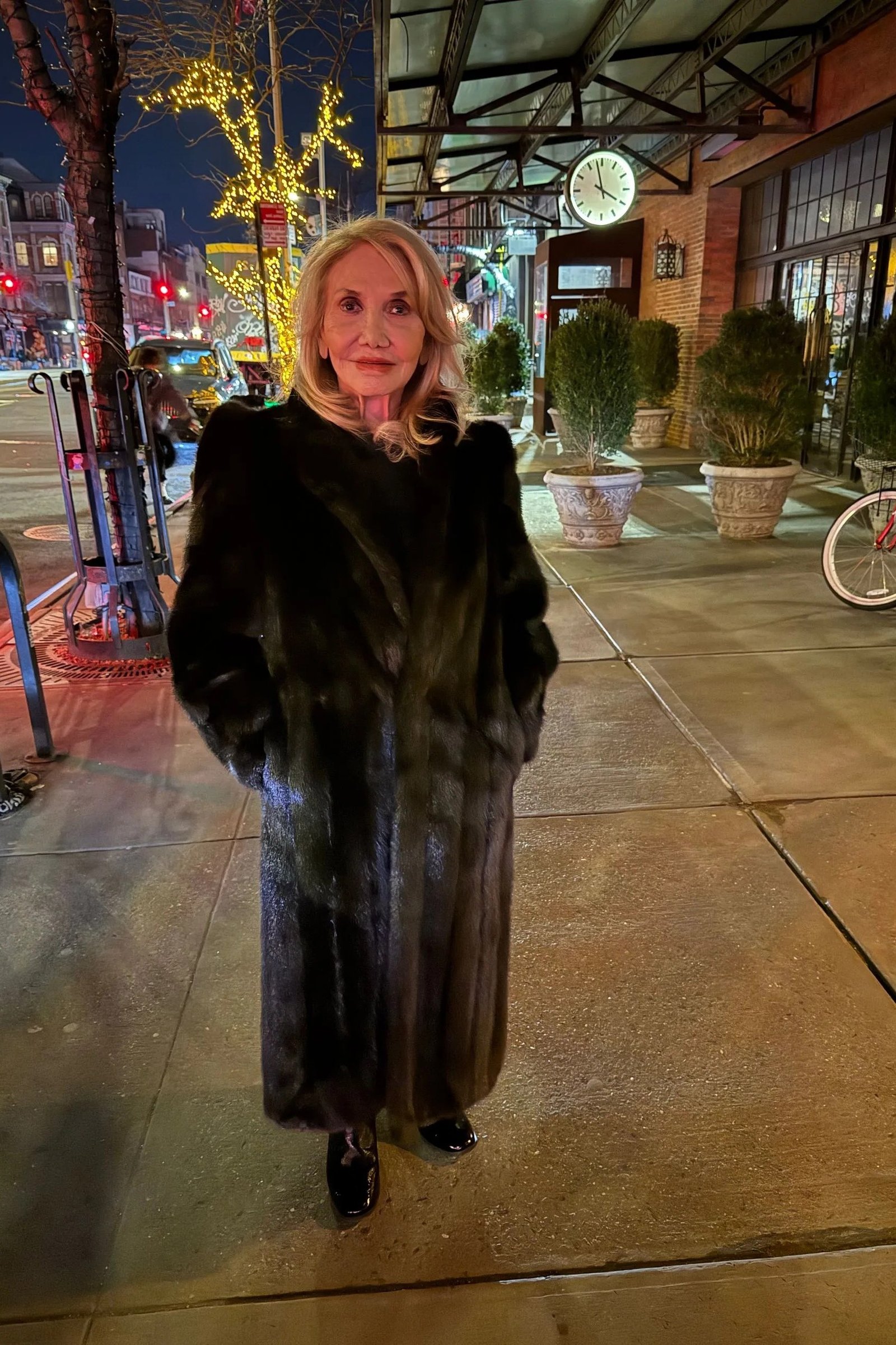 winter date night outfit for women over 60: black fur coat styled on a night street