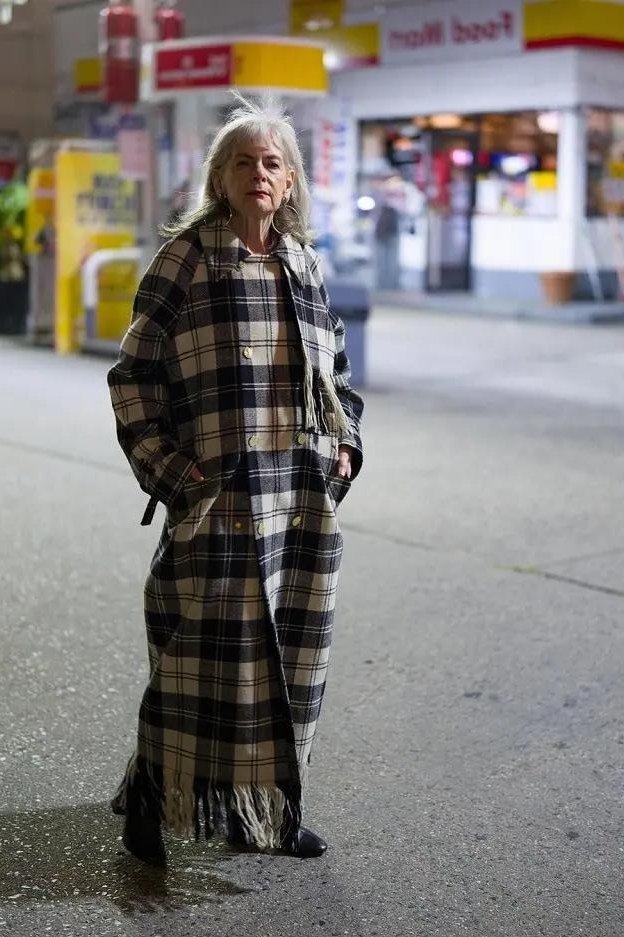 winter date night outfit for women over 60: plaid blanket coat styled on a city street