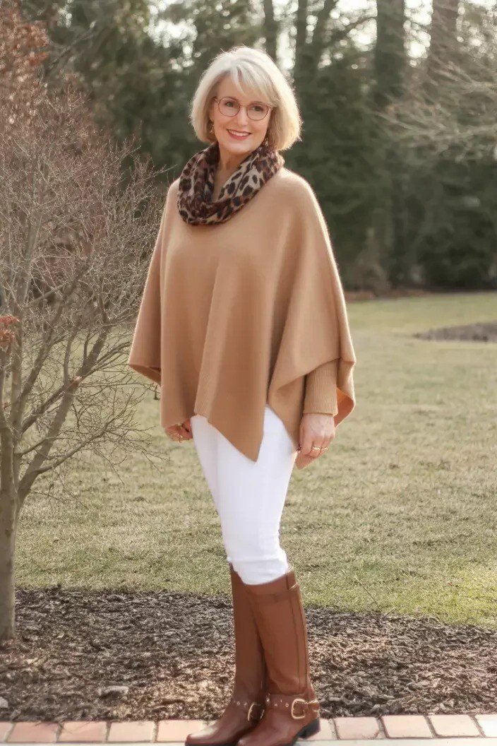 Camel Poncho with Leopard Scarf and White Trousers on older woman, cozy winter outfit for women over 60