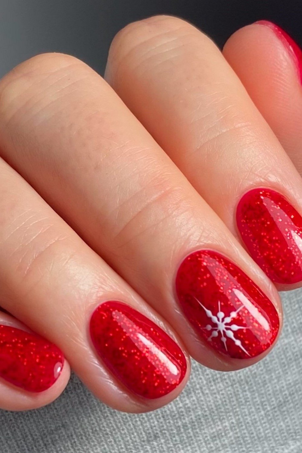 Glossy red short winter nails with white starburst nail art