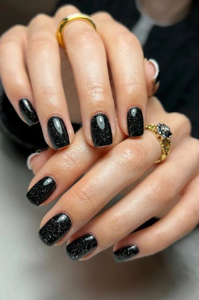 Black glossy short winter nails with silver glitter accents