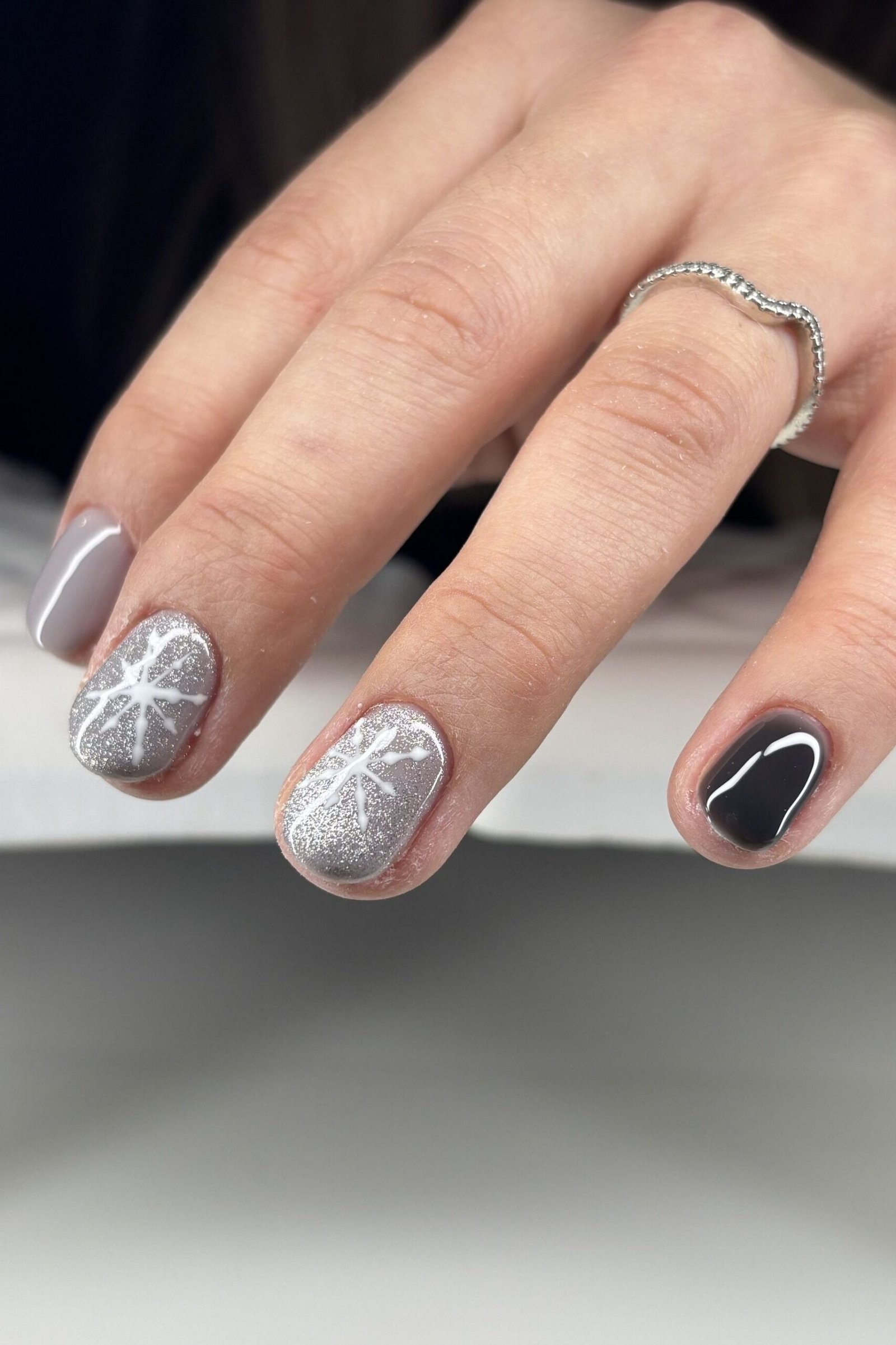 Silver shimmer nails with black accent nail and snowflakes
