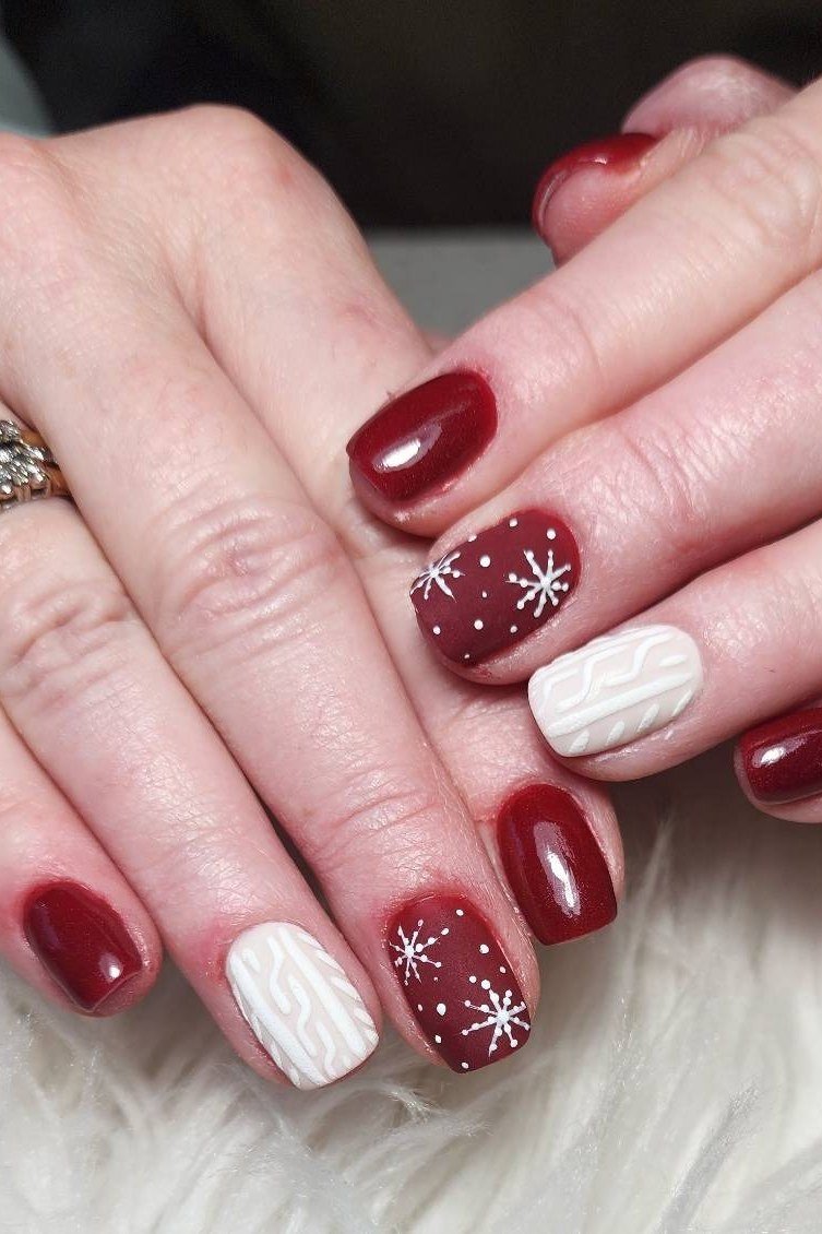 Burgundy nails with white sweater knit nail art and snowflakes