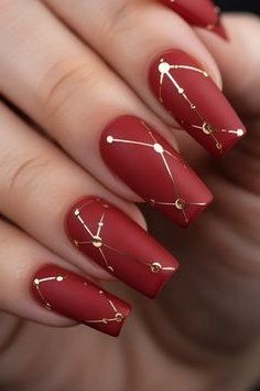 Matte terracotta red nails with gold constellation lines