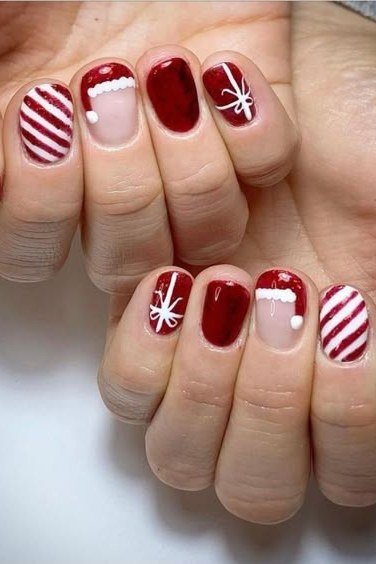 Red nails with santa hat, candy cane and snowflake art