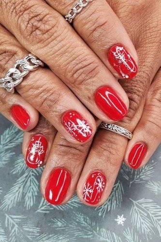 Red short winter nails with snowflakes on mature hands