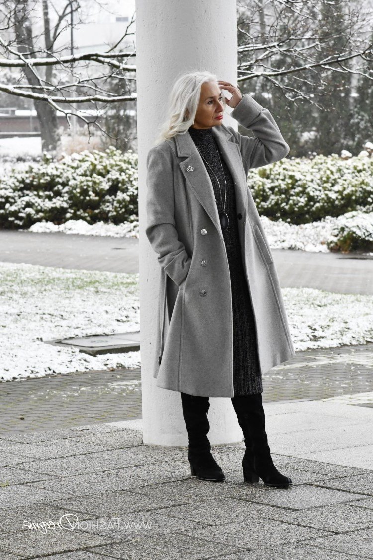 Mid gray wool coat over dark knit top with black skinny jeans and knee boots, simple winter outfit for older women