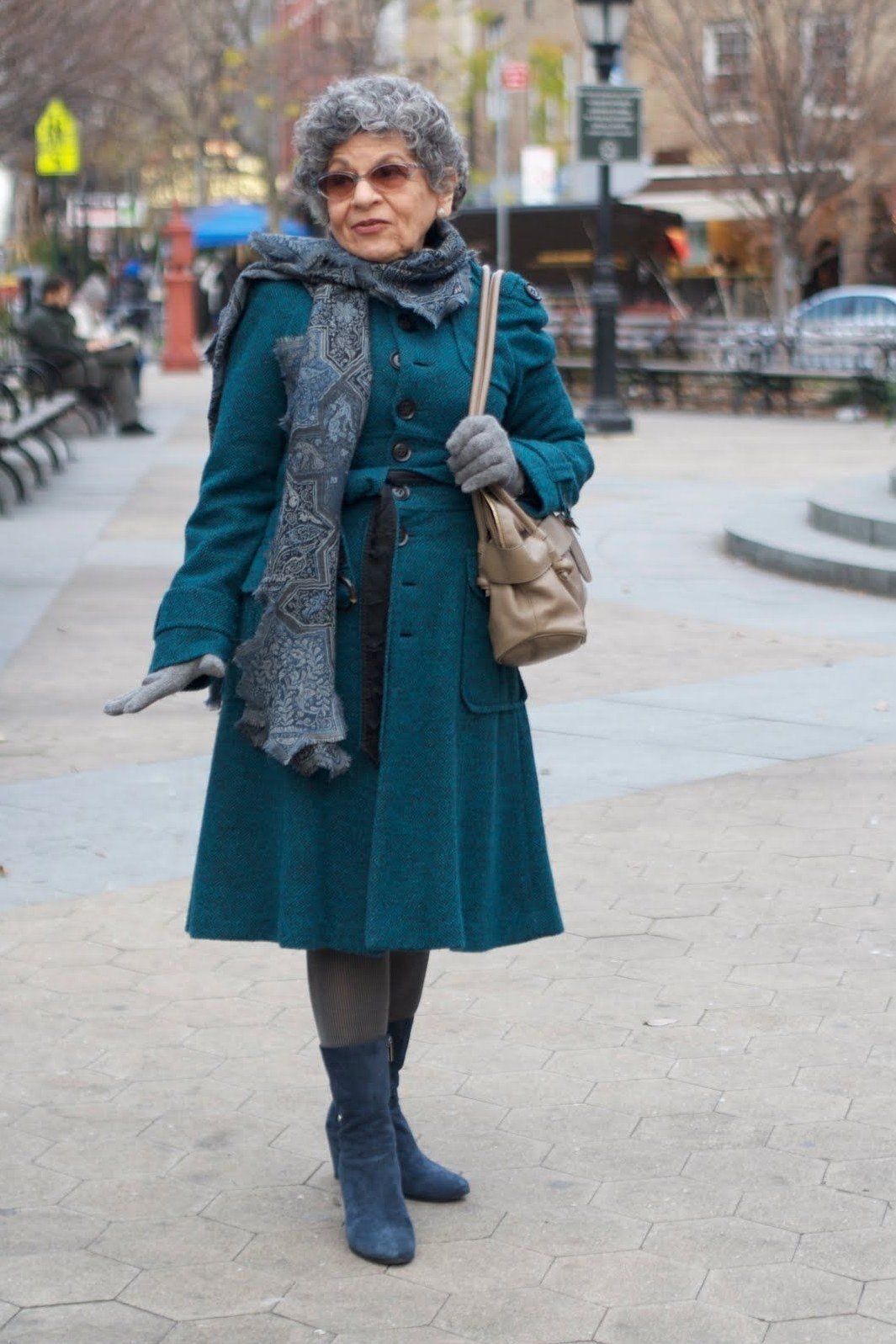 Rich teal wool coat over gray knit dress with gray scarf and blue ankle boots, jewel tone winter outfit for women over 60