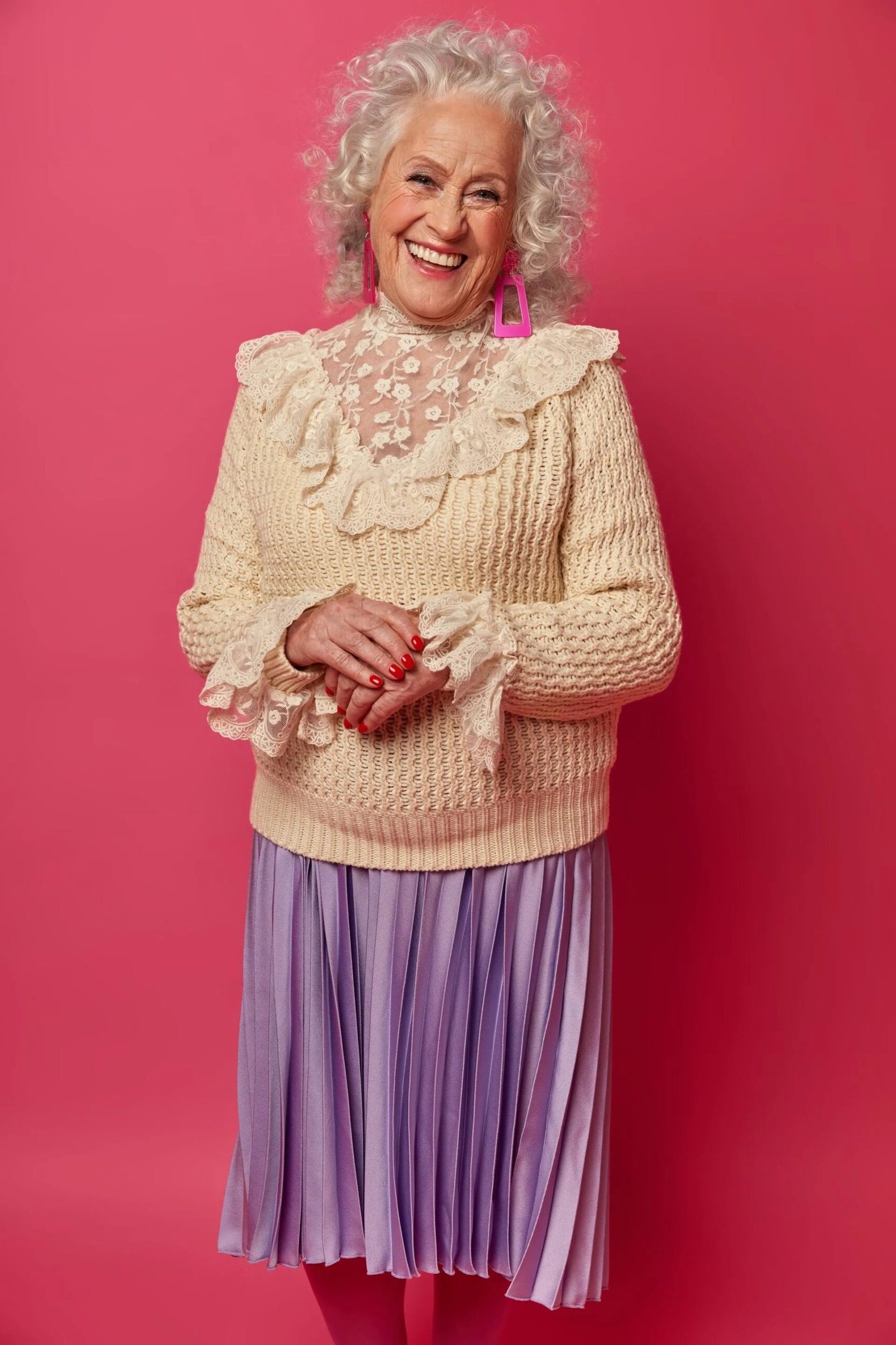 Cream cable knit sweater with lace collar over lilac pleated midi skirt, romantic winter outfit for women over 60