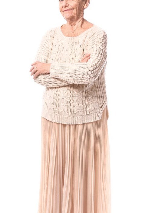 Cream cable knit sweater over blush pink pleated maxi skirt, soft romantic winter outfit for older women