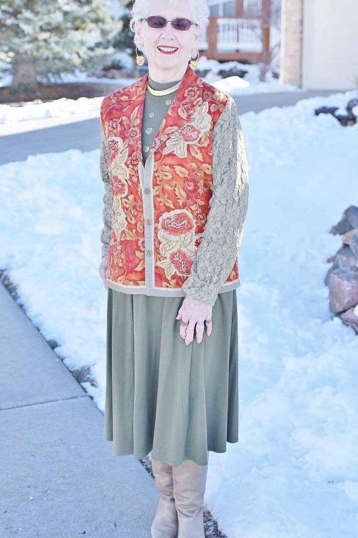 Red paisley quilted vest over cream sweater and sage green midi skirt, folk inspired winter vest outfit for women over 60