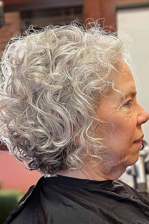 Short wolf cut for women over 60 - silver curly wolf, salon cape, side view