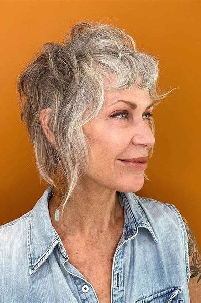 Short wolf cut for women over 60 - gray textured wolf, windswept layers, orange background, side view
