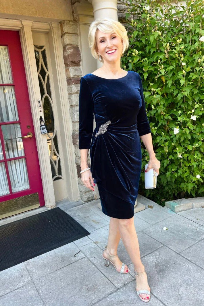 navy blue velvet midi dress at front door with christmas lights