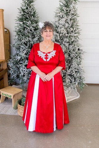 Red and White Gown by Flocked Trees worn by older woman, red and white gown with embroidery by flocked trees