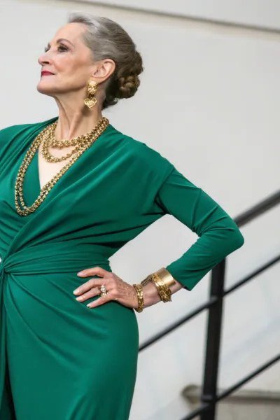 emerald long sleeve wrap dress with gold jewelry on stairs