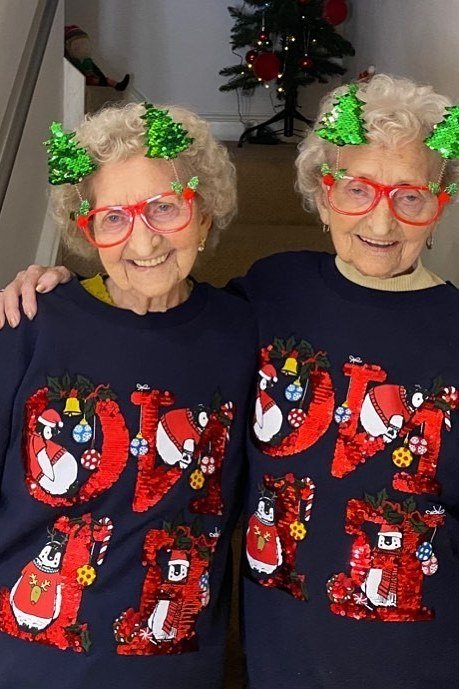 Matching Navy Noel Sweaters worn by older woman, two women in matching navy NOEL sweaters with tree headbands