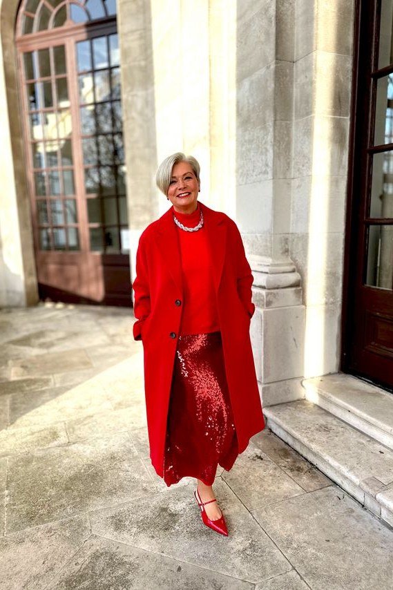 red coat over red sequin skirt on city street at christmas