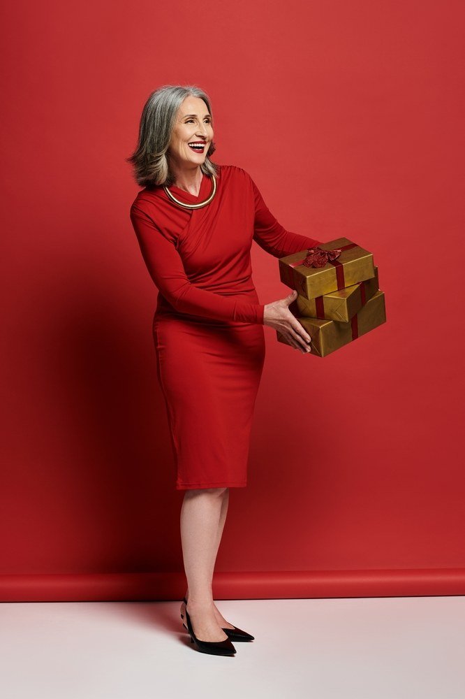 red sheath dress with gift boxes against red christmas backdrop