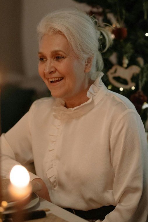 Cream High-Neck Blouse by Candlelight worn by older woman, cream high-neck blouse by candlelight at Christmas table
