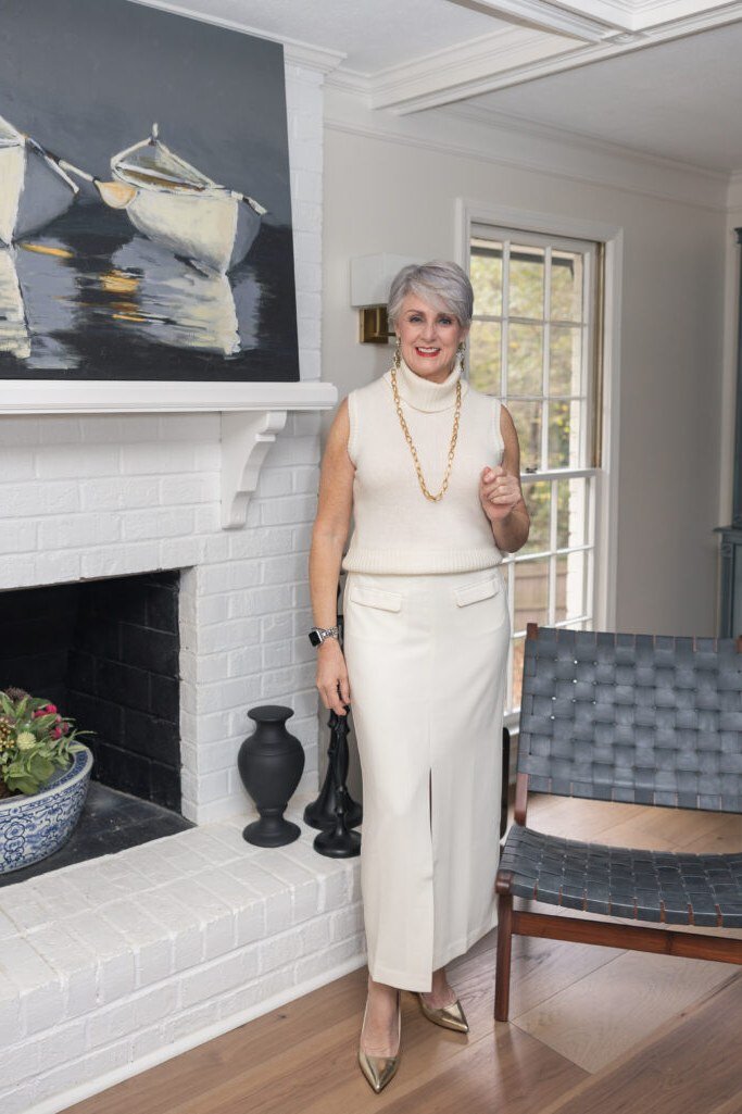 cream turtleneck with cream trousers by fireplace for christmas