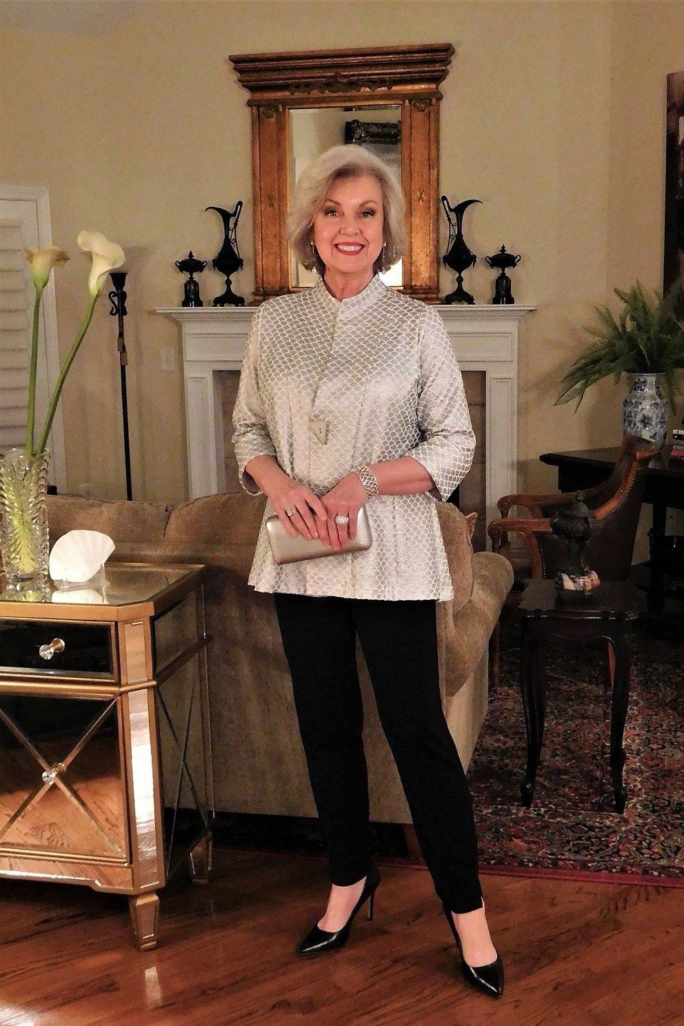 champagne knit top with black trousers in cozy living room