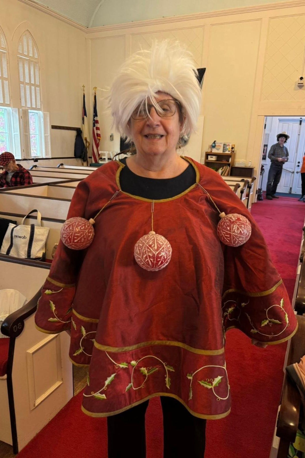 Red Poncho with Pom-Pom Ornaments worn by older woman, red poncho with pom-pom ornaments at church