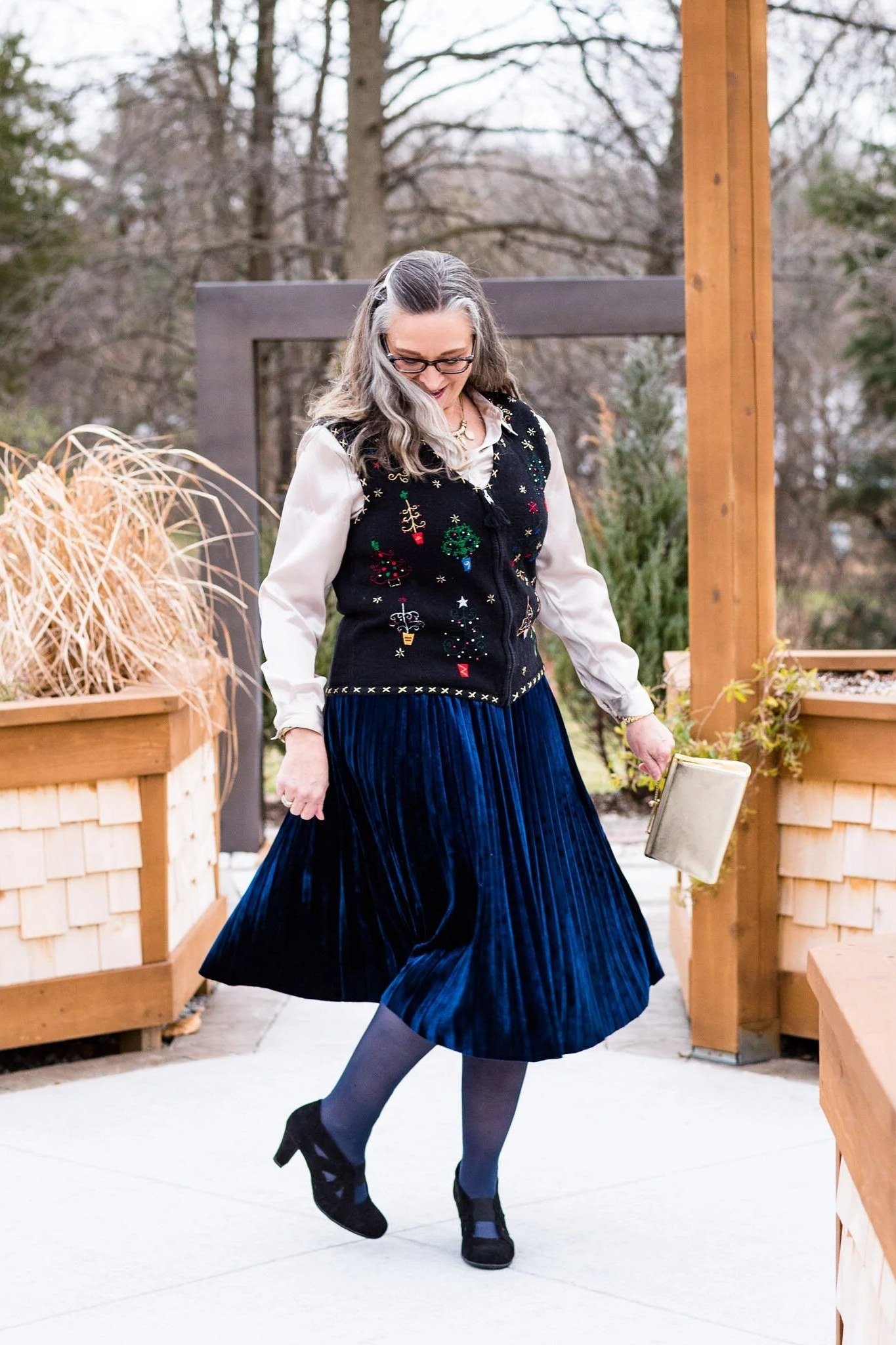 Navy Pleated Midi Skirt with a Dark Vest worn by older woman, navy pleated midi skirt with dark vest outdoors