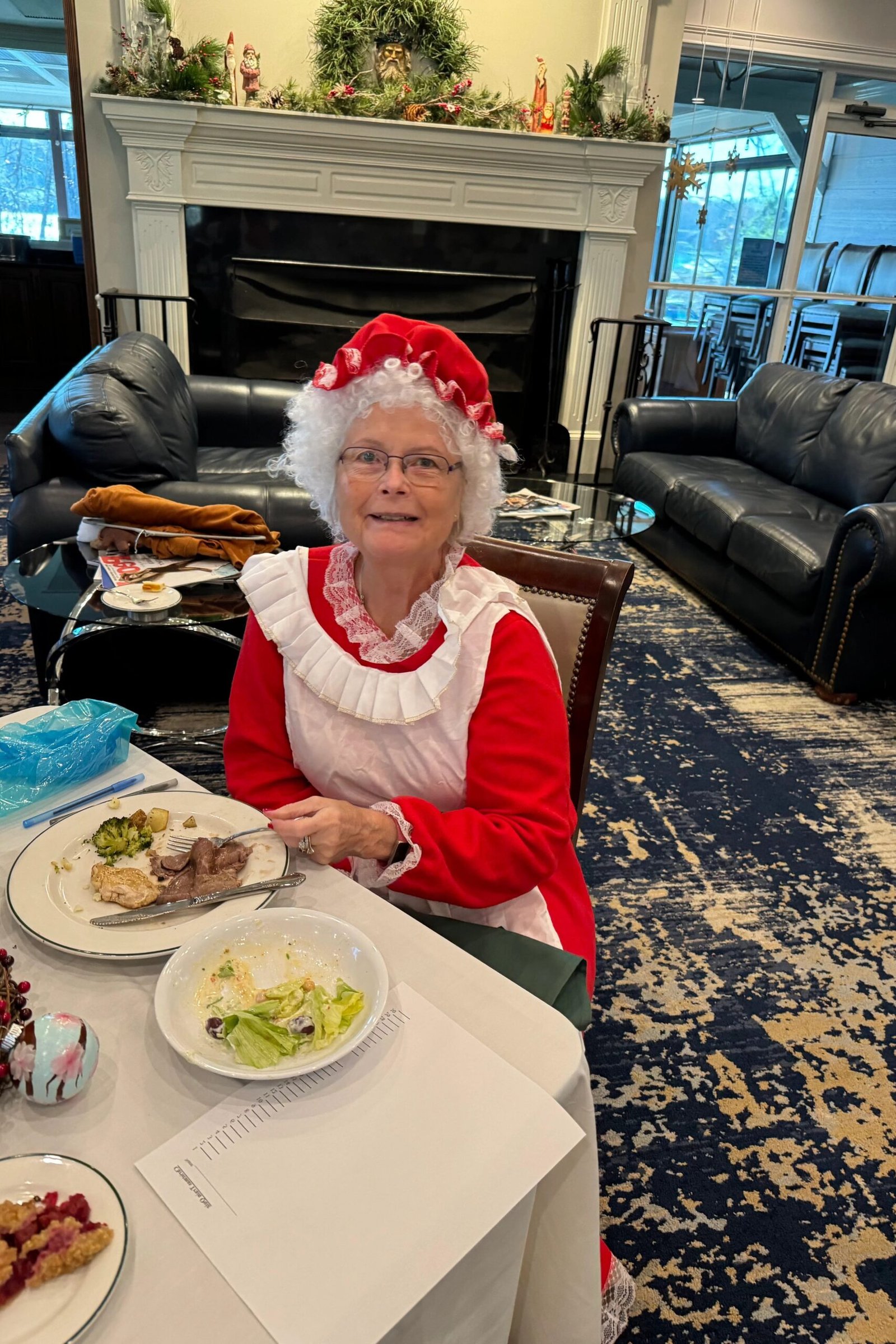 Mrs. Claus Red and White Dress at Dinner worn by older woman, mrs Claus red and white dress seated at dinner table