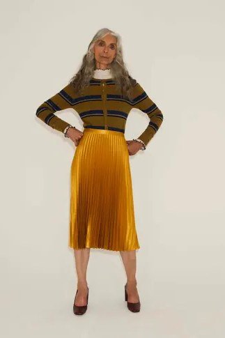 grey turtleneck with gold foil skirt seated for holiday dinner
