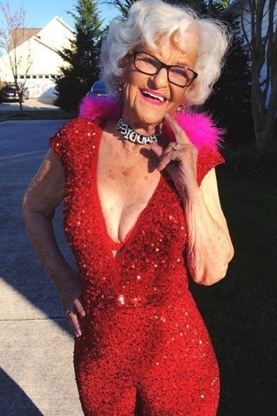 Red sequin Christmas gown with pink feather boa outdoors, festive holiday outfit for women over 70