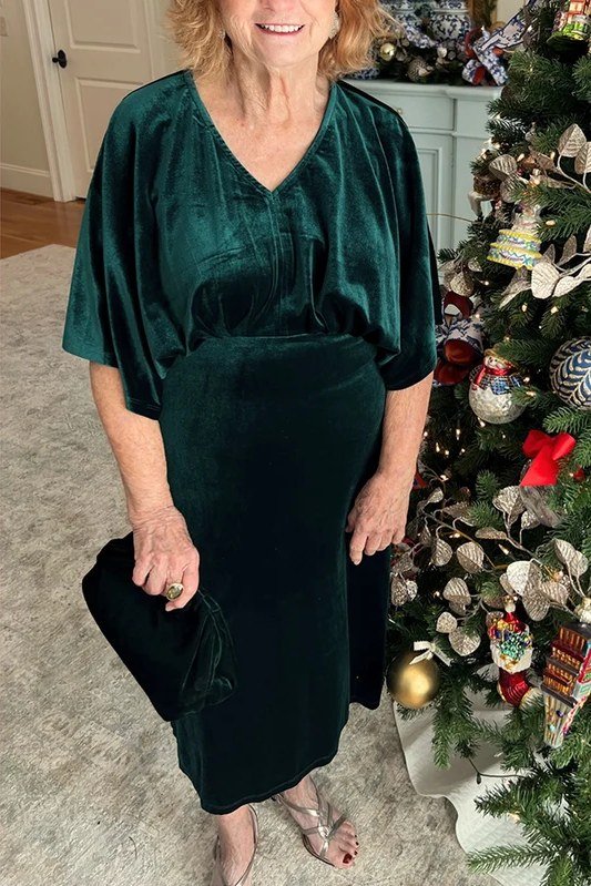 Dark green velvet v-neck midi Christmas dress by tree, festive holiday outfit for women over 70